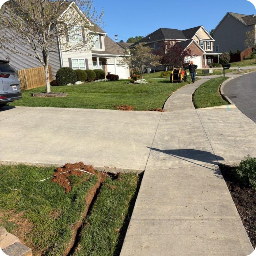 Brightspeed fiber line installation under a residential driveway.
