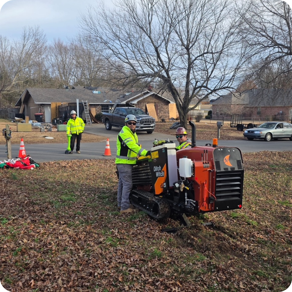 Brightspeed technician crews digging under a residential street with specialized machinery to install underground fiber for high-speed internet service.