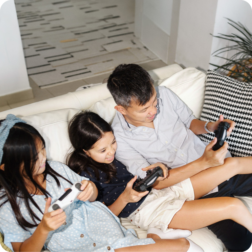 Family playing video games together on a couch with Brightspeed Fiber Internet for seamless gaming and streaming.